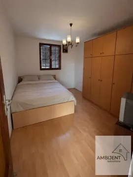 Spavaća soba sa bračnim krevetom i velikim drvenim ormarom. - image 5