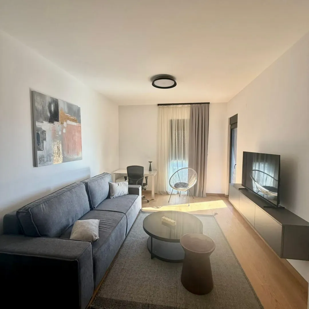 Modern and bright living room with a sofa, coffee table, and TV.