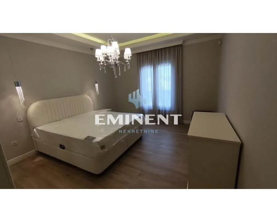 Spacious bedroom with a double bed and a chandelier.