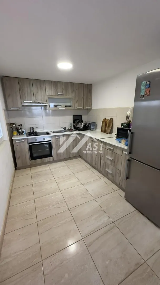 Kitchen equipped with wooden cabinetry and built-in home appliances.