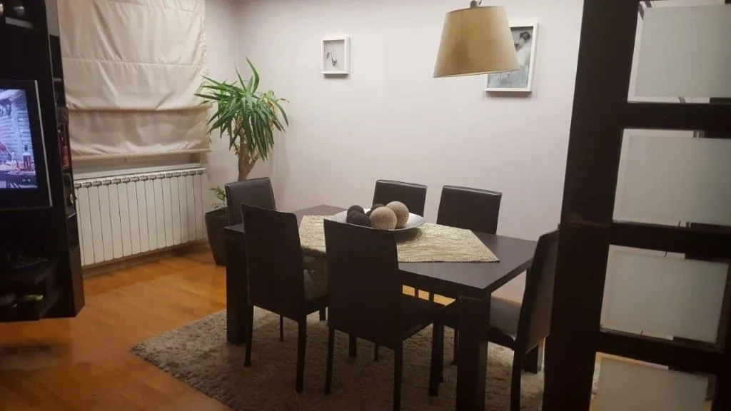 Dining area with a dark table and chairs connected to the living room.