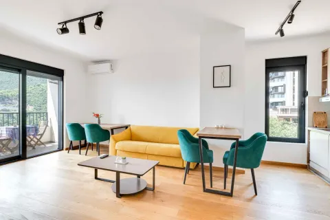 Living room with a yellow sofa, dining table, and access to the terrace. - image 3