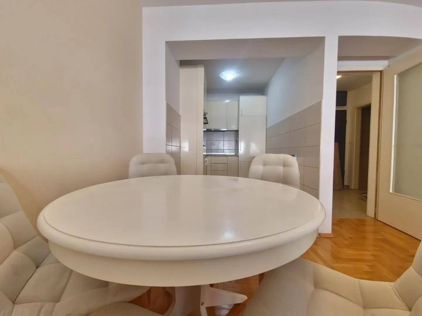 Dining area with a round table and chairs, overlooking the kitchen.