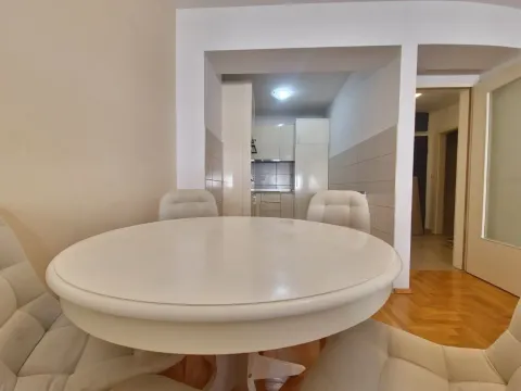 Dining area with a round table and chairs, overlooking the kitchen. - image 20