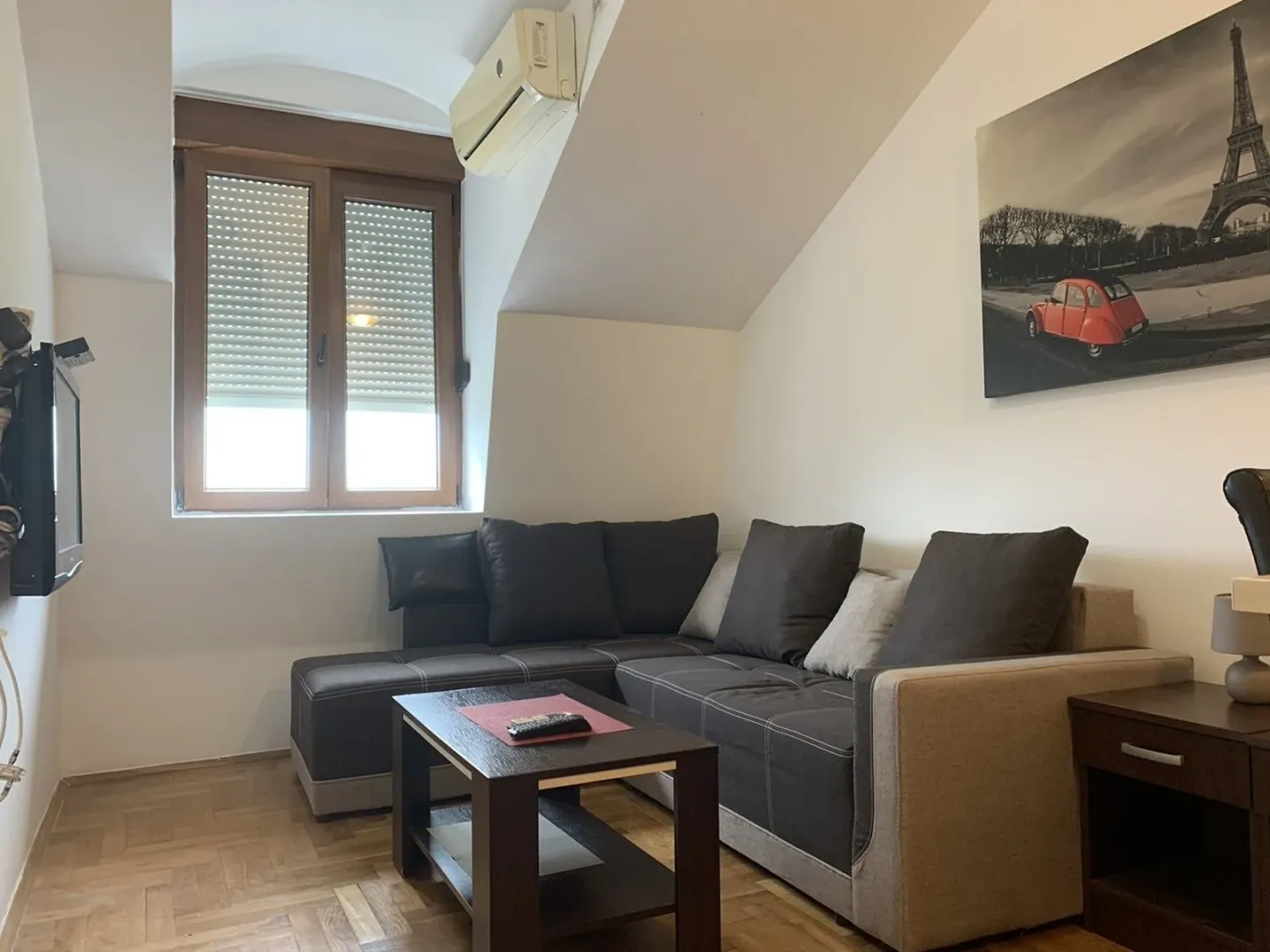 Living room with a corner sofa, a wooden coffee table, and a TV.