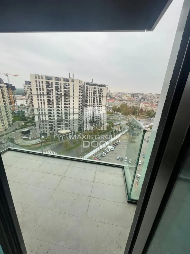 Modern balcony with a glass railing and city view.