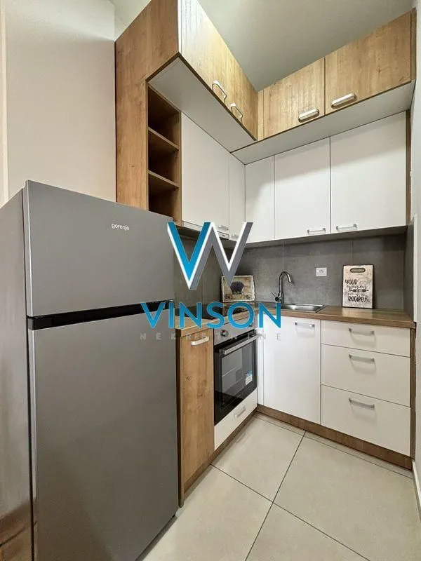 Small equipped kitchen with white and wooden elements.