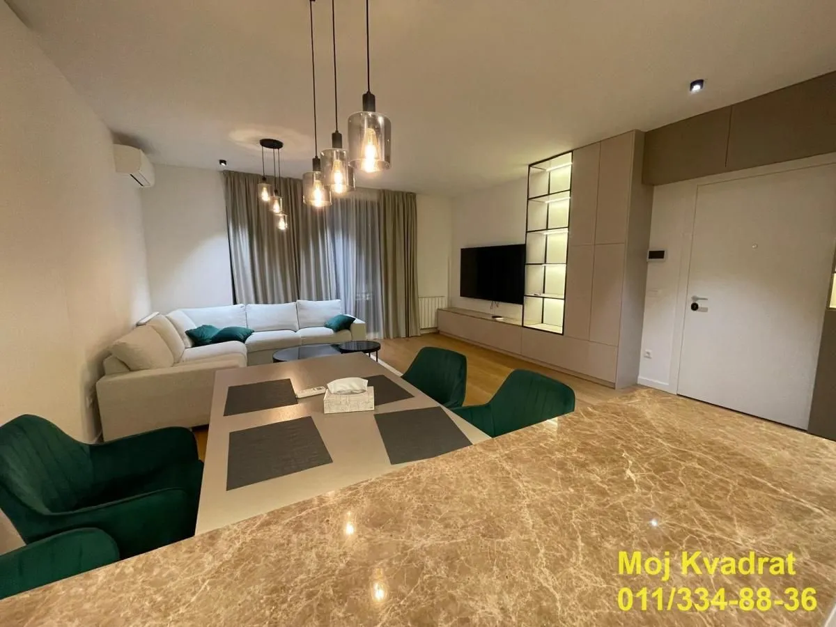 Living room with sofa, dining table and built-in TV unit.