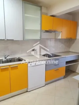 Kitchen with orange and grey cabinets and built-in appliances. - image 33
