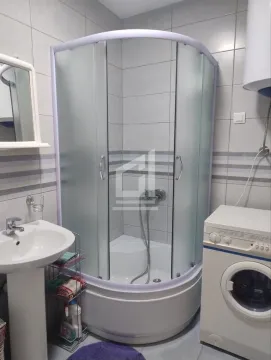 Bathroom with a shower cabin, washbasin, and washing machine. - image 3
