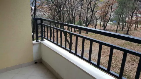 Balcony with a dark metal railing overlooking the surrounding trees. - image 3