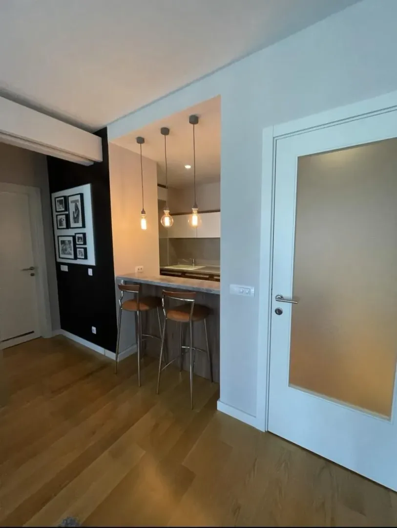Small kitchen with a breakfast bar and bar stools in an apartment.