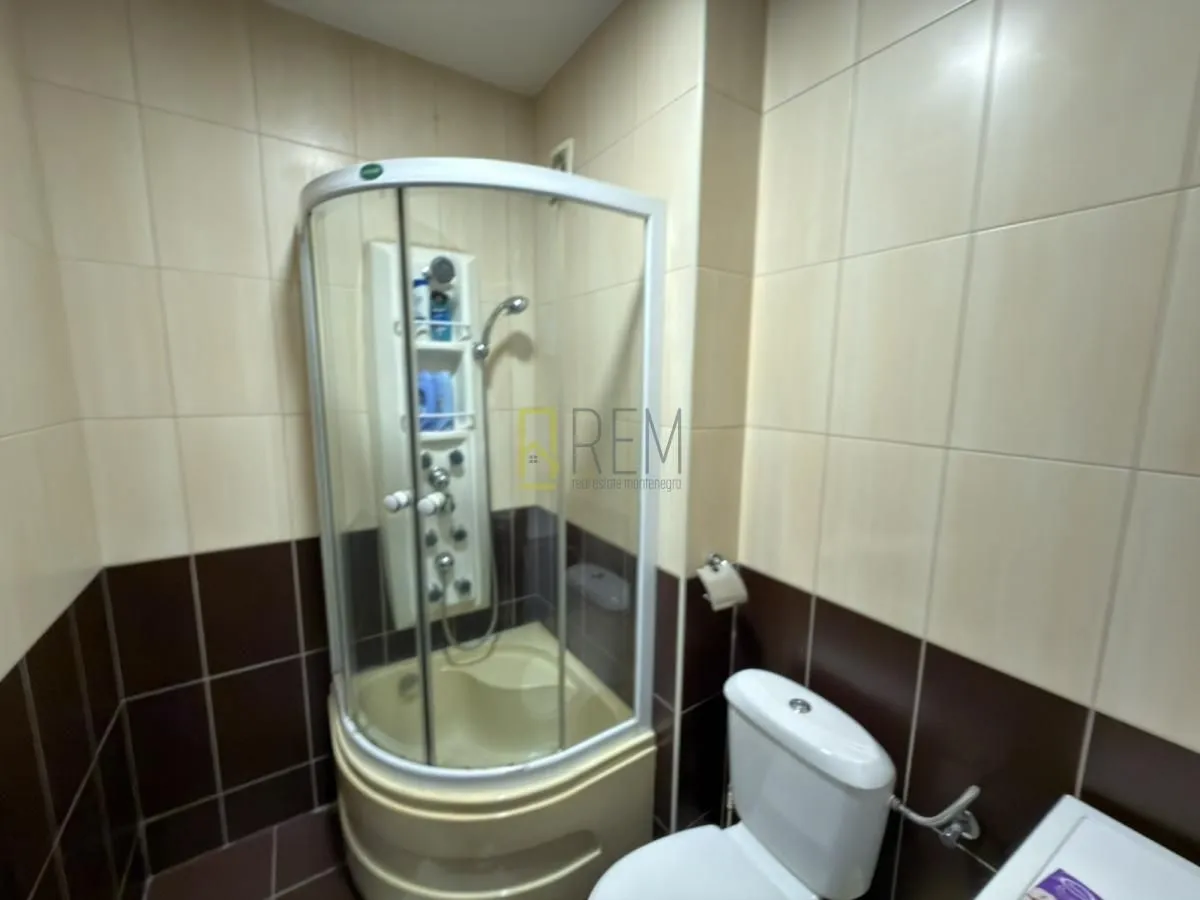 Manje kupatilo sa tuš kabinom i wc šoljom.