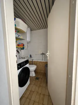 Manje kupatilo sa kadom, toaletom i mašinom za veš. - image 5
