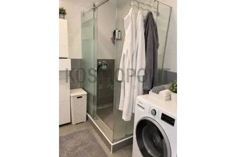 Bathroom with a shower cabin and washing machine. - image 10