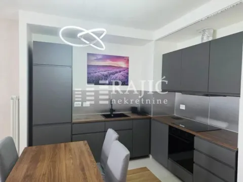 Modern kitchen with dark cabinetry and a dining table. - image 4