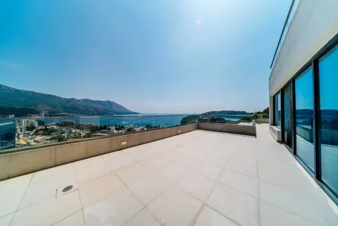 Velika popločana terasa sa staklenom ogradom i pogledom na more i grad. - image 13
