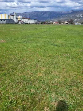 Prostran zeleni plac sa pogledom na planine u pozadini. - image 4