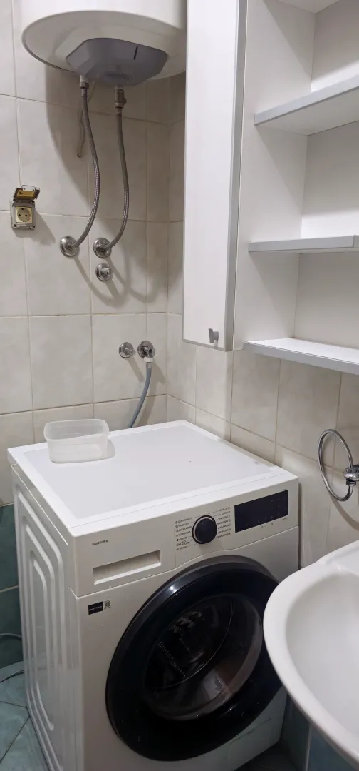 Kupatilo sa veš mašinom, bojlerom i lavaboom.