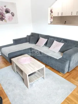 Living room with a sectional sofa and a wooden coffee table. - image 2