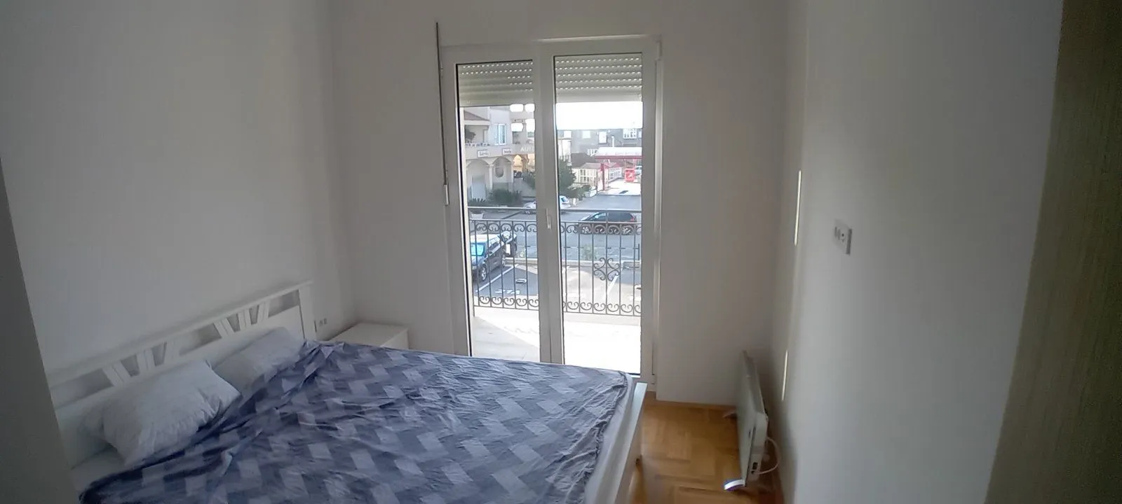 Bright bedroom with a double bed and balcony access.