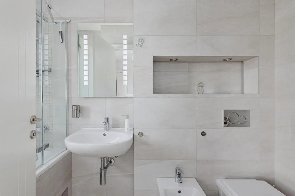 Modern bathroom equipped with a washbasin, mirror, and sanitary fixtures.