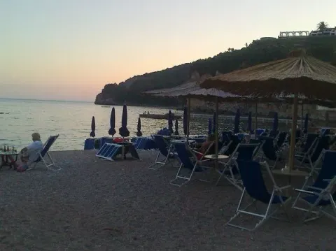 Pogled na plažu sa ležaljkama i suncobranima u sumrak. - image 6