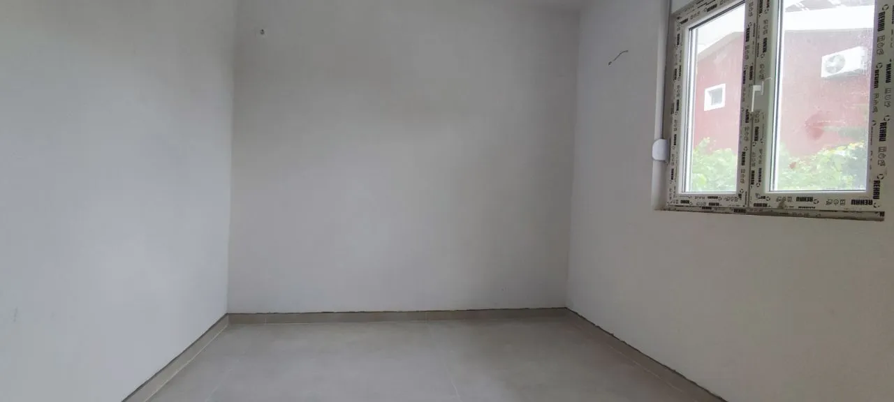 Empty unfurnished room with white walls and a window.