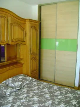 Spavaća soba sa krevetom, drvenim ormarom i plakarom sa kliznim vratima. - image 5