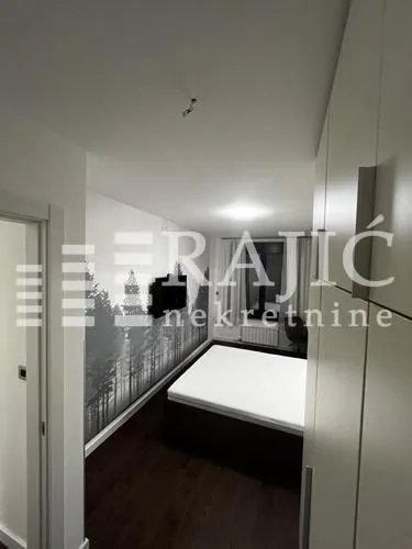 Furnished bedroom with a double bed and a fitted wardrobe.