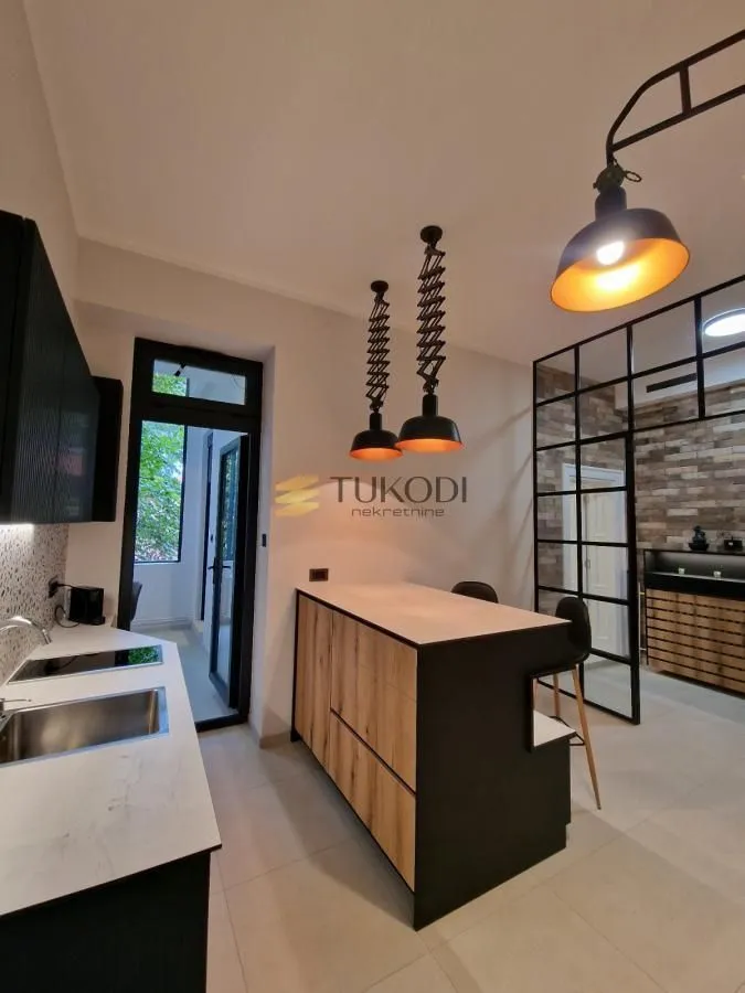 Modern kitchen with a breakfast bar and pendant lights.