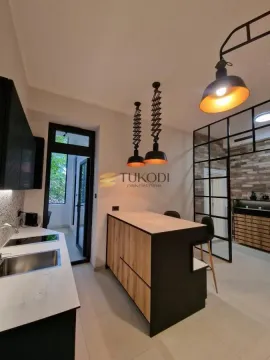 Modern kitchen with a breakfast bar and pendant lights. - image 7