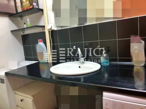 Smaller bathroom with a washbasin and black tiles. - image 10