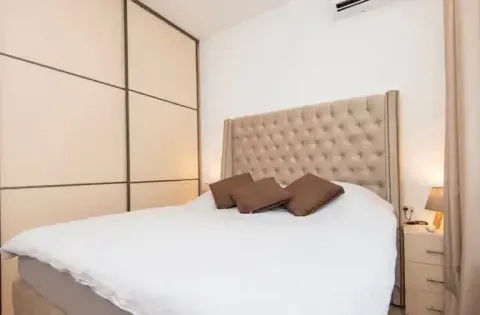 Bedroom with a double bed, upholstered headboard, and a built-in wardrobe. - image 6