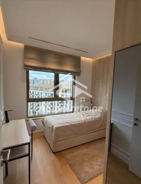 Furnished bedroom with a bed, desk, and a window. - image 11