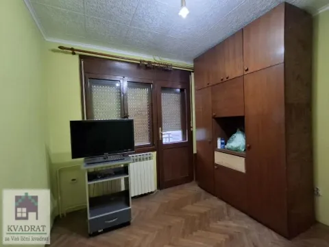 Spavaća soba sa drvenim ormanom, televizorom i parketom. - image 18
