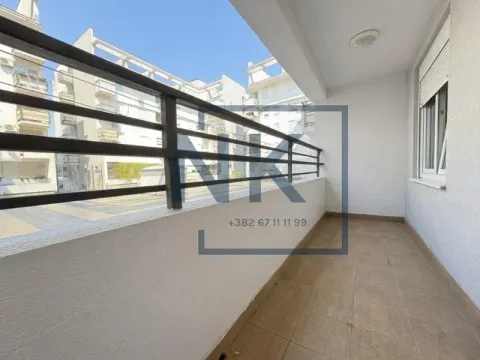 Covered balcony with metal railing and view of buildings. - image 9