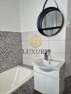 Bathroom equipped with a sink, bathtub, and mirror. - image 4
