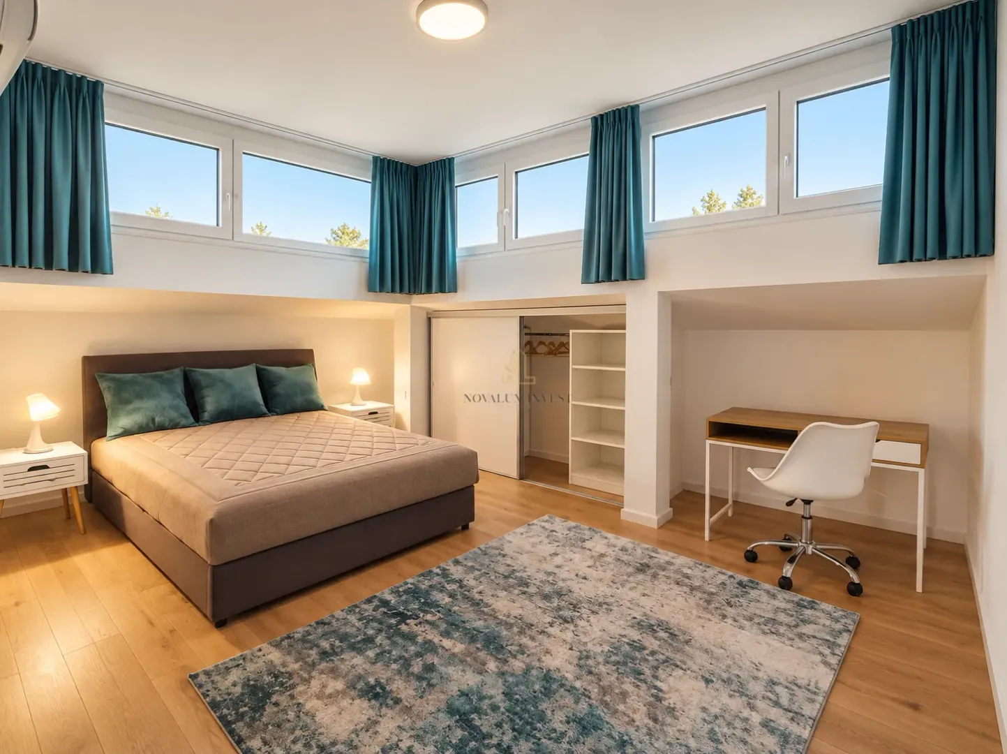 Spacious bedroom with a large double bed, desk, and wardrobe.