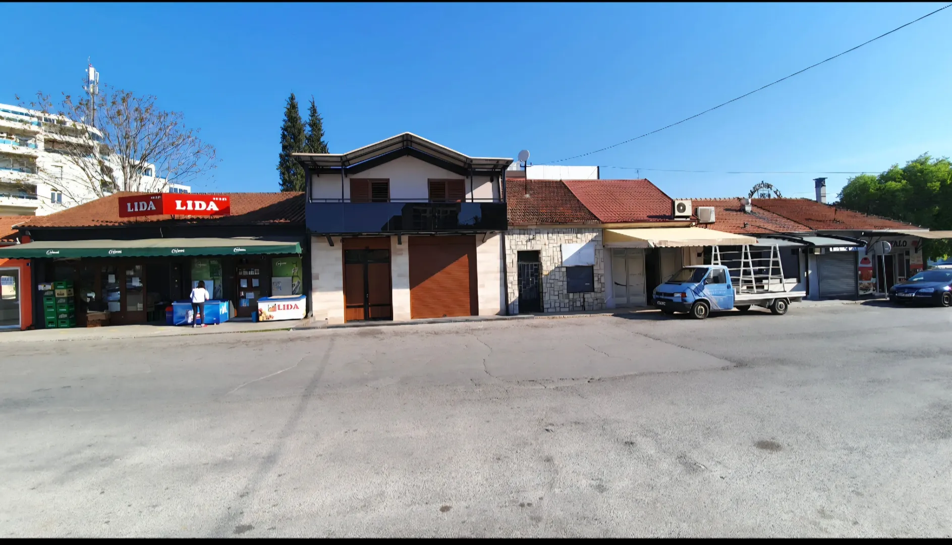 View of the facade and entrance to commercial premises with parking.