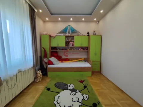 Children's bedroom with a bed, green closets, and parquet flooring. - image 25