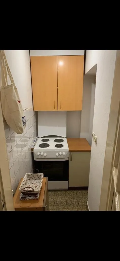 Small kitchen with a stove and wall cabinets.
