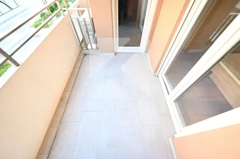 Pogled na prostrani balkon sa popločanim podom i staklenim vratima. - image 10