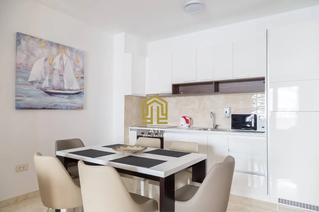 Modern kitchen with a dining area and white cabinets.