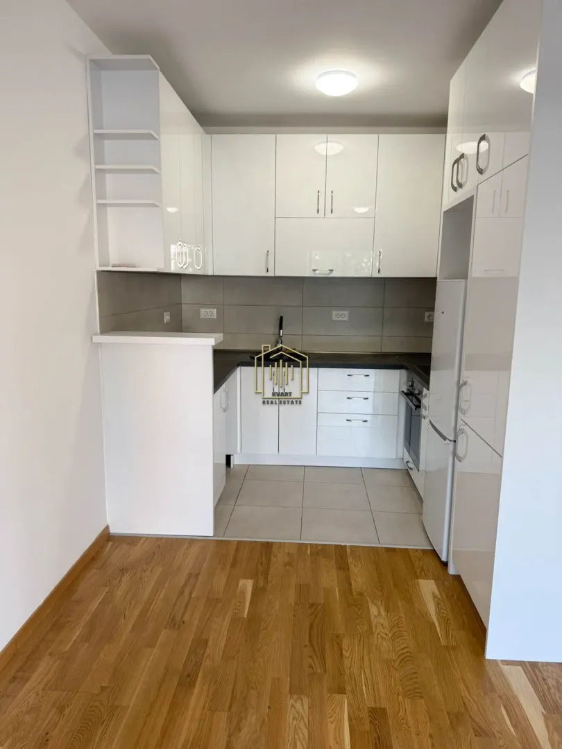 Modern kitchen with white cabinetry and built-in appliances.