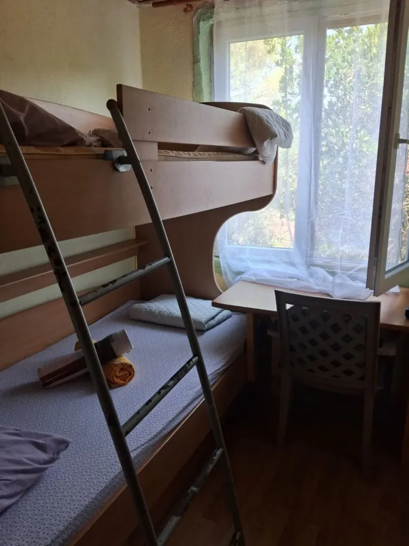 Children's bedroom with a bunk bed and a desk by the window.