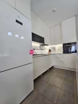 Modern white kitchen with built-in appliances and gray floor tiles. - image 3