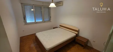 Spavaća soba sa bračnim krevetom, noćnim stočićima i parketom na podu. - image 9