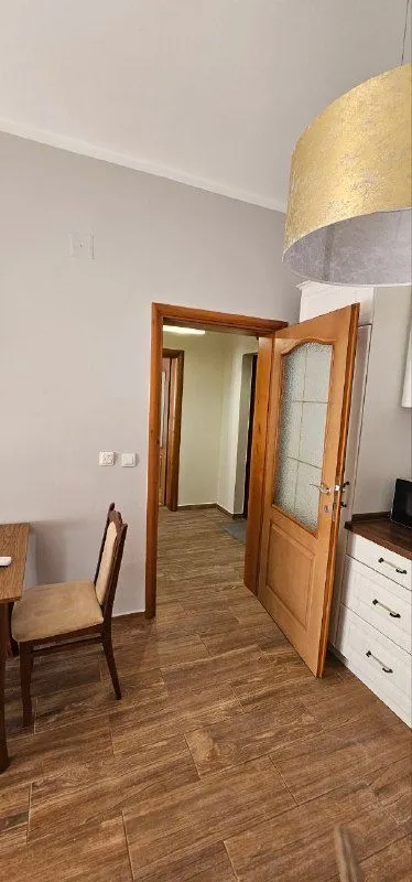 Pogled na kuhinju i drvena vrata koja vode u hodnik.