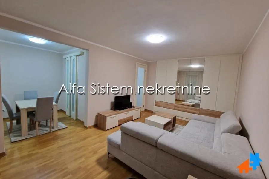 Prostrani dnevni boravak sa garniturom i trpezarijom u nastavku.